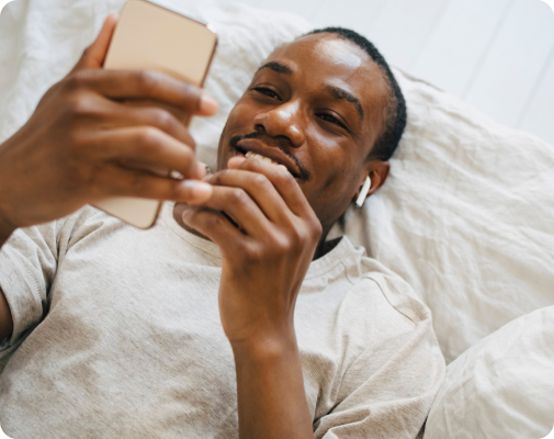 Homme souriant devant un Smartphone